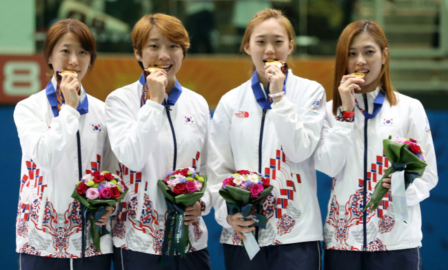 Team Korea bites gold medals after defeating China in the women's sabre fencing team event at the Asian Games in Incheon on Tuesday.
(Yonhap)
