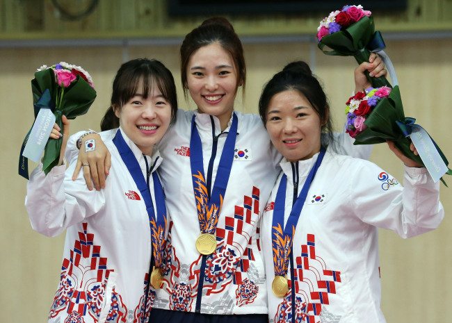 <YONHAP PHOTO-1039> <아시안게임> 환한표정의 태극낭자 (인천=연합뉴스) 최재구 기자 = 24일 인천 옥련국제사격장에서 열린 2014 인천 아시안게임 사격 여자 50m 소총 단체전에서 금메달을 획득한 여자사격팀 나윤경(왼쪽부터), 정미라, 음빛나가 시상대에서 환하게 웃고 있다. 2014.9.24 jjaeck9@yna.co.kr/2014-09-24 11:33:34/ <저작권자 ⓒ 1980-2014 ㈜연합뉴스. 무단 전재 재배포 금지.>
Korea’s Na Yoon-kyung (from left), Jeong Mi-ra and Eum Bit-na pose after winning gold in the rifle prone on Wednesday.   Yonhap