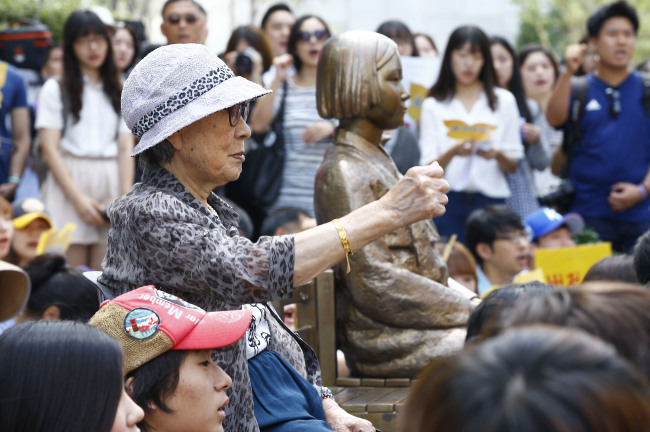 <YONHAP PHOTO-0431> '일본은 반성하라' (서울=연합뉴스) 이상학 기자 = 10일 서울 종로구 중학동 일본대사관 앞에서 열린 일본군 위안부 문제해결을 위한 정기 수요집회에서 김복동 할머니와 참석자들이 일본의 반성을 촉구하고 있다. 2014.9.10 leesh@yna.co.kr/2014-09-10 13:16:44/ <저작권자 ⓒ 1980-2014 ㈜연합뉴스. 무단 전재 재배포 금지.>
Kim Bok-dong, a former “comfort woman,” protests next to a bronze statue dedicated to the wartime sex slaves in front of the Japanese Embassy in Seoul on Sept. 10.   Yonhap