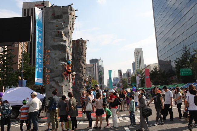 지난 22일 서울 ‘차없는 날’ 광화문 대로에서 시민들이 암벽타기를 하고 있다.