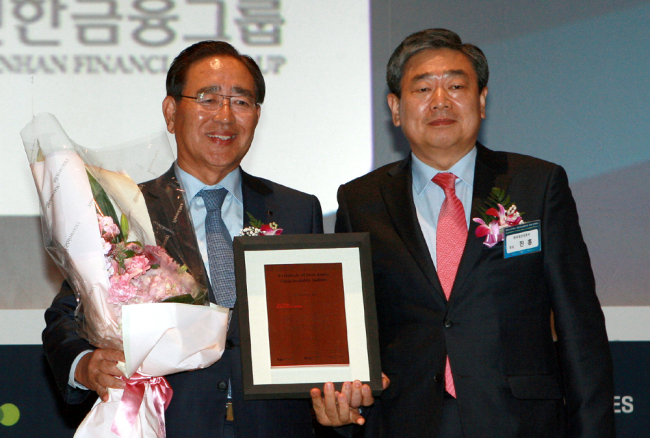 Shinhan Financial Group chairman Han Dong-woo (left) poses after receiving an award at the Dow Jones Sustainability Index International Conference in October 2013. The group was also present at this year’s DJSI, becoming the first South Korean financial firm to be included two years in a row.    Shinhan Financial Group
