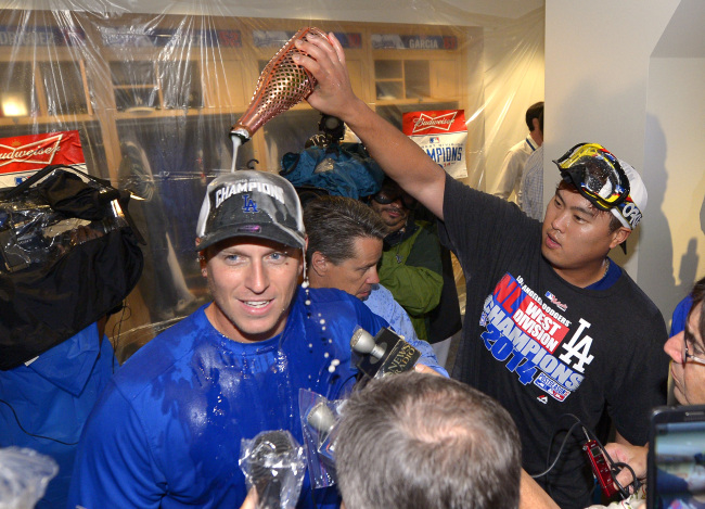 Los Angeles Dodgers’ A.J. Ellis (left) is doused with champagne by Ryu Hyun-jin after they defeated the San Francisco Giants and clinched the National League West Division title on Wednesday.   AP-Yonhap