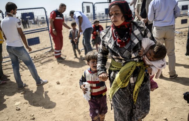 Syrian Kurds cross the border between Syria and Turkey at the southeastern town of Suruc in Sanliurfa province, Wednesday. (AFP)