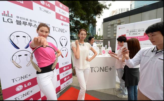 Models pose with LG Electronics’ Tone Plus wireless headsets during a promotional event in Seoul on Friday.   LG Electronics