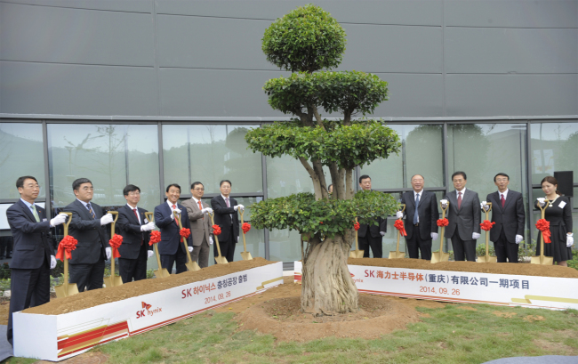 SK hynix CEO Park Sung-wook (third from left) and others pose in its new memory chip plant in Chongqing, China, Friday.   SK hynix
