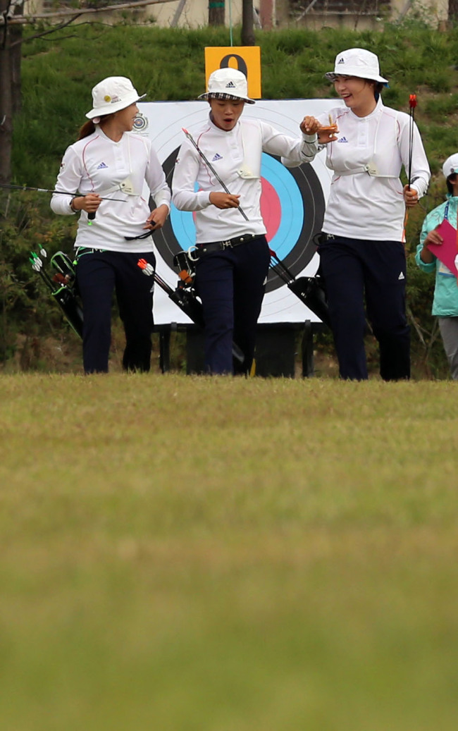 <YONHAP PHOTO-0406> <아시안게임> 4강 진출한 한국양궁 태극낭자 (인천=연합뉴스) 최재구 기자 = 26일 인천 계양아시아드양궁장에서 열린 여자 양궁 리커브 단체전 8강경기에서 한국 양궁팀이 점수를 확인하고 밝은 표정으로 사대로 돌아오고 있다. 2014.9.26 jjaeck9@yna.co.kr/2014-09-26 10:57:35/ <저작권자 ⓒ 1980-2014 ㈜연합뉴스. 무단 전재 재배포 금지.>
Korean women’s archery team   Yonhap
