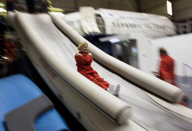 A participant slides down an escape slide during a British Airways flight safety course at the airline’s Cranebank training facility near Heathrow airport in London. (AP)
