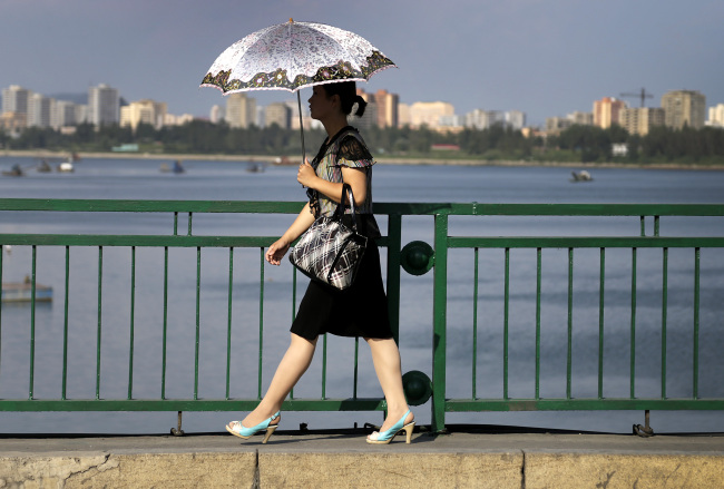A North Korean woman walks along the Taedonggang River in Pyongyang, North Korea, Aug. 30, 2014.   AP-Yonhap