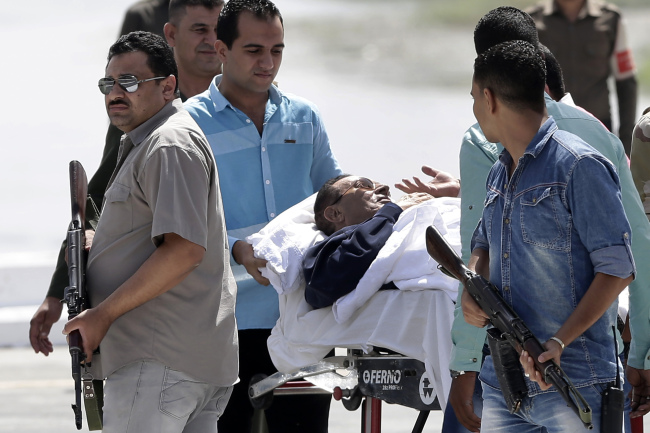 Egyptian medics and army personnel escort former Egyptian President Hosni Mubarak from a helicopter to the Maadi Military Hospital, following a hearing in his retrial at the Cairo Police Academy in Cairo on Saturday.   AP-Yonhap