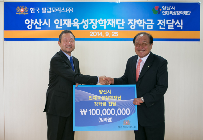 Philip Morris Korea’s head Chung Il-woo (left) poses with Ahn Yoon-han, chief of a scholarship center in Yangsan, at Philip Morris Korea’s plant.   Philip Morris Korea