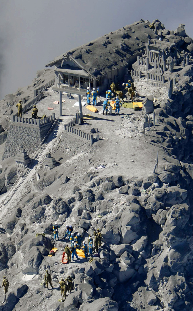 Rescue workers search for missing people on Mount Ontake after it erupted in central Japan on Monday.   AP-Yonhap