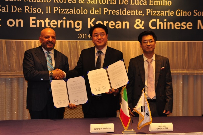 Cafe Milano Korea CEO Park Ji-hoon (center) signs an agreement on opening high-end diners with Salvatore de Riso business manager Sartoria de Luca (left) at a Seoul hotel on Tuesday.