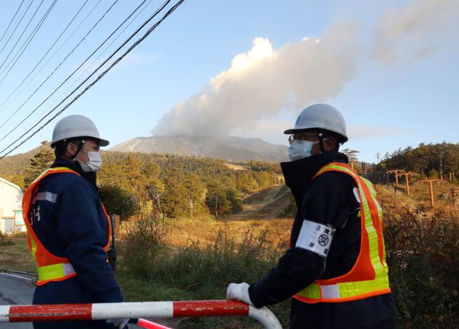 Security persons stand guard at the entrance of a road leading to the mountain trail of Mount Ontake in Nagano prefecture, Japan, Tuesday, three days after the volcano erupted.   AFP-Yonhap