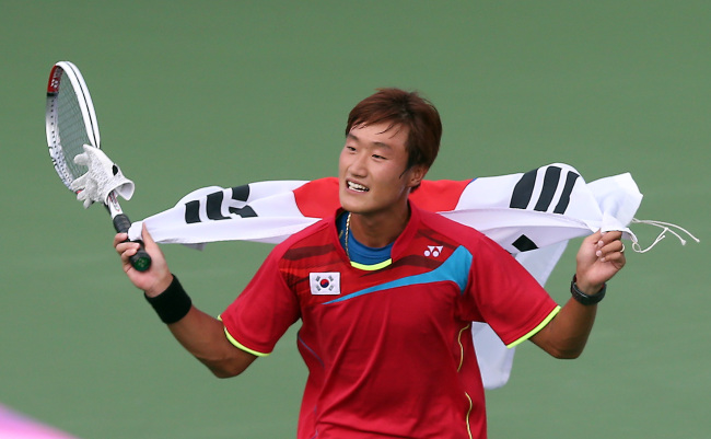 <YONHAP PHOTO-1369> <아시안게임> 태극기 들고 뛰는 김형준 (인천=연합뉴스) 신준희 기자 = 30일 오후 인천 열우물 경기장에서 열린 2014 인천아시안게임 정구 남자 단식 결승전에서 승리해 금메달을 획득한 한국 김형준이 태극기를 들고 코트를 뛰고 있다. 2014.9.30 hama@yna.co.kr/2014-09-30 16:34:22/ <저작권자 ⓒ 1980-2014 ㈜연합뉴스. 무단 전재 재배포 금지.>
South Korea’s Kim Hyeong-jun won the soft tennis gold medal in the men’s singles event at the Asian Games on Tuesday. Kim dispatched Edi Kusdaryanto of Indonesia 4-0 in just 13 minutes at Yeorumul Tennis Courts’ Show Court in the Asiad host city.   Yonhap