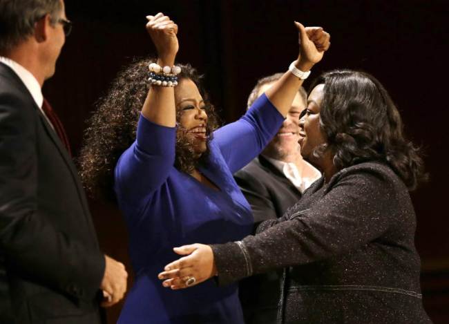 Oprah Winfrey (center) and television producer and writer Shonda Rhimes (right) embrace on stage during the W.E.B. Du Bois medal award ceremonies at Harvard University on Tuesday.   AP