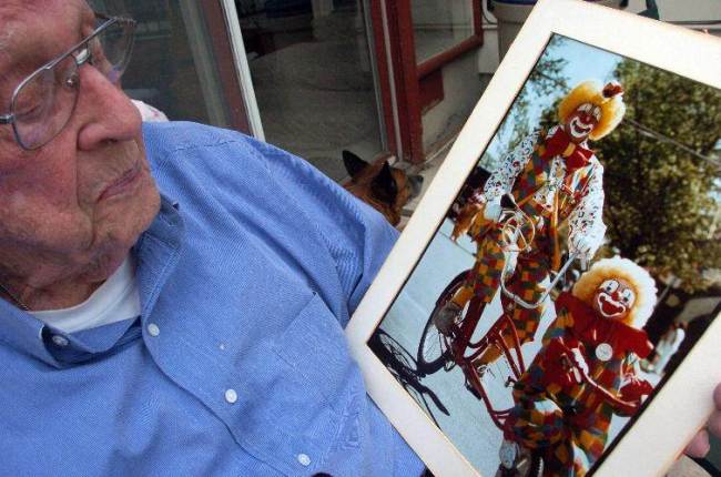 Floyd Creekmore holds a photo of himself performing in a 1988 parade as “Creeky” the clown at his home in Billings, Montana.   AP