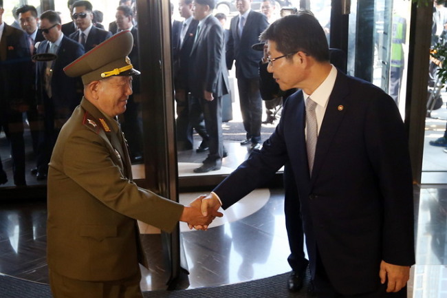 Hwang Pyong-so (left), director of North Korean military's General Political Bureau, shake hands with South Korean Unification Minister Ryoo Kihl-jae at Incheon Oakwood Hotel on Saturday. (Yonhap)