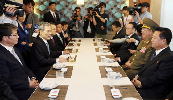 High-ranking officials of South Korea (seated left) and North Korea (seated right) pose for the media at the Yeongbingwan building on Saturday. (Yonhap)