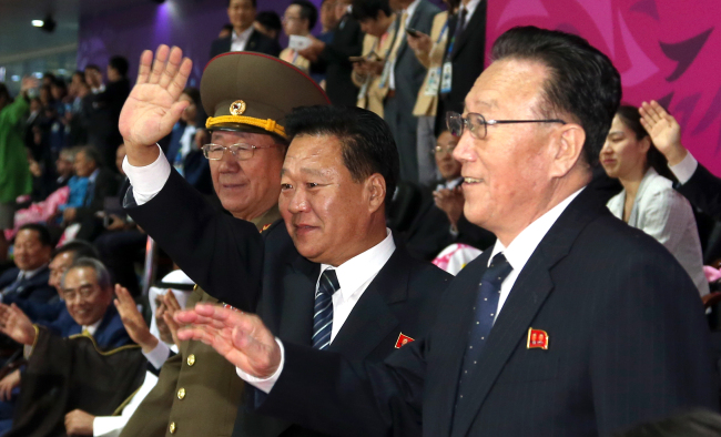 Hwang Pyong-so (from left), head of the North Korean Army’s General Political Bureau; Choe Ryong-hae, secretary of the Worker’s Party; and Kim Yang-gon, veteran official in charge of South Korean affairs, wave to their compatriot participants during the closing ceremony of the 2014 Incheon Asian Games on Saturday.   Yonhap