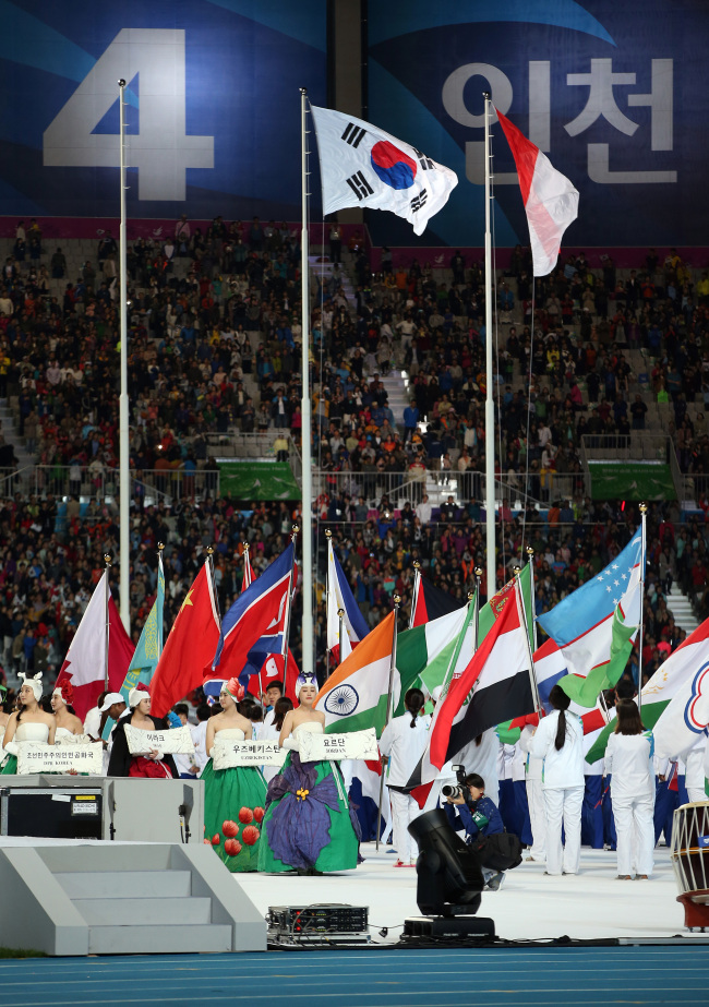The Indonesian flag (right) is raised at the closing ceremony of the 17th Asian Games at the Asiad Main Stadium in Incheon on Saturday.   Yonhap
