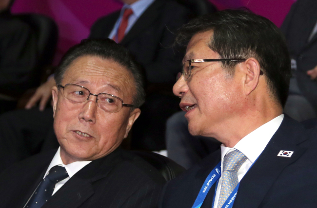 South Korea’s Unification Minister Ryoo Kihl-jae (right) talks with Kim Yang-gon, director of the North Korean United Front Department of the ruling Workers’ Party, during the closing ceremony of the Asian Games at the Incheon Asiad Main Stadium on Saturday.   Yonhap