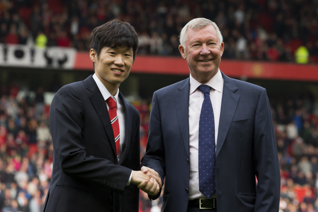 Former Manchester United midfielder Park Ji-sung (left) shakes hands with former coach Alex Ferguson as Park is introduced as the new ambassador for the club before the team’s English Premier League soccer match against Everton at Old Trafford Stadium, Manchester, England, Sunday.   AP-Yonhap