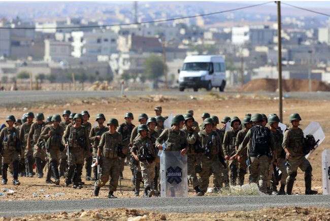 Turkish soldiers take their positions a few hundred meters from the Turkey-Syria border in Mursitpinar near Suruc, Turkey, Sunday.   AP-Yonhap