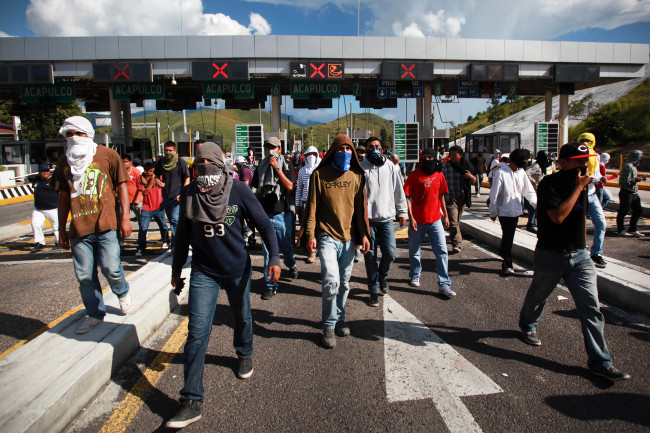 Students and relatives of missing students occupy a toll booth as they block a main highway in the city of Chilpancingo, Mexico, Sunday.   AP-Yonhap