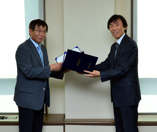 Yu Kun-ha (right), head of the digital service center at Herald Corp., poses after signing a partnership agreement with Kim Kyu-tae, the senior managing director of the Association of High Potential Enterprises of Korea. The two sides will cooperate to globally promote Korean mid-sized firms.   Yoon Byung-chan/The Korea Herald