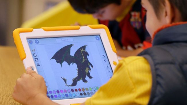 A child works with a ScratchJr program on an iPad in Medford, Massachusetts.   AP-Yonhap