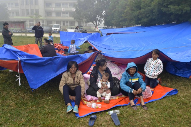 Residents gather outdoors in the aftermath of an earthquake in the town of Yongping of Jinggu county, Yunnan province, China, Wednesday.   AP-Yonhap