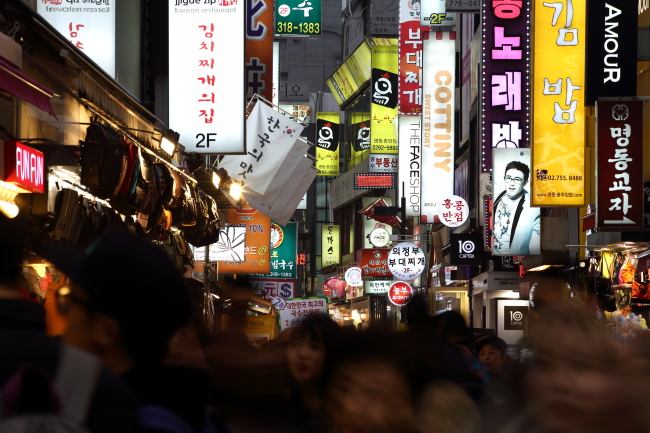 Illuminated signboards light up a street in the evening in the Myeong-dong.   (Bloomberg)