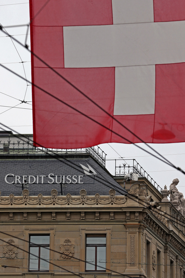 A Swiss national flag flies near the headquarters of Credit Suisse in Zurich, Switzerland.   Bloomberg
