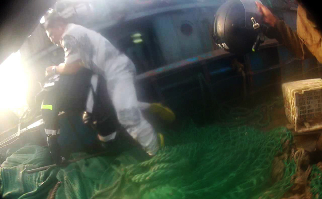 In this screen capture from a video released by the Coast Guard on Saturday, the captain (right) of a Chinese fishing vessel caught for illegal fishing in Korean waters attacks a Coast Guard officer during a raid on Friday, prompting other officers to open fire and resulting in his death.   Coast Guard