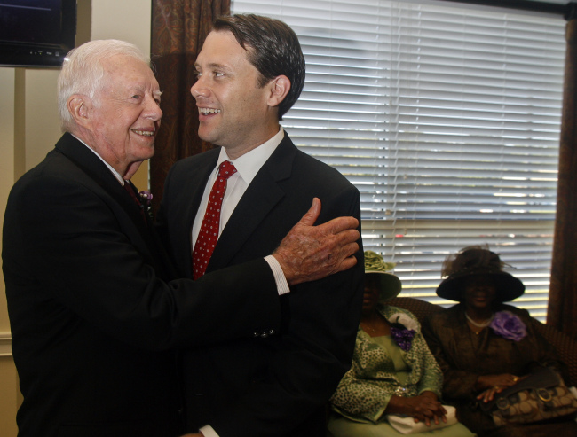 Former President Jimmy Carter (left) hugs his grandson, Georgia Democratic candidate for governor Jason Carter, as they meet Sunday at Mt. Zion Baptist Church in Albany, Georgia.    AP-Yonhap