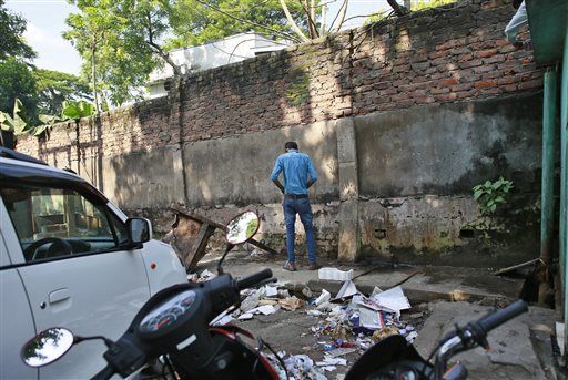 A man urinates on a wall in Gauhati, India.   AP
