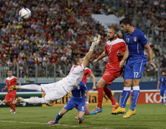 <YONHAP PHOTO-0142> Italy’s Graziano Pelle, right, tries to scores as Malta goalkeeper Andrew Hogg, left, and Malta’s Andre Agius go to stop him during the Euro 2016 qualifying soccer match between Malta and Italy, at the National Stadium Ta' Qali, in Valletta, Malta, Monday, Oct. 13, 2014. (AP Photo/Antonio Calanni)/2014-10-14 05:46:45/ <저작권자 ⓒ 1980-2014 ㈜연합뉴스. 무단 전재 재배포 금지.>
Italy’s Graziano Pelle (right) attempts a shot on goal against Malta on Monday.   AP-Yonhap