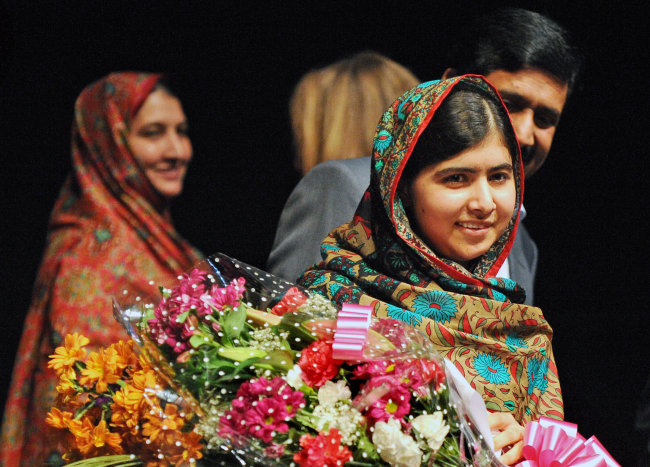 Malala Yousafzai holds flowers after speaking during a media conference at the Library of Birmingham, after she was named a cowinner of the Nobel Peace Prize, in Birmingham, England, Friday.   AP-Yonhap