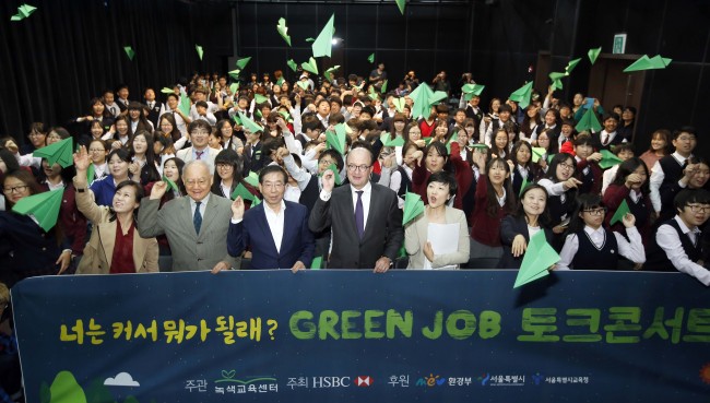 Seoul Mayor Park Won-soon (front row, fourth from left), HSBC president and CEO Martin Tricaud (front row, center) and students fly paper airplanes to celebrate the first session of the bank’s mentoring program in Seoul on Monday.    HSBC