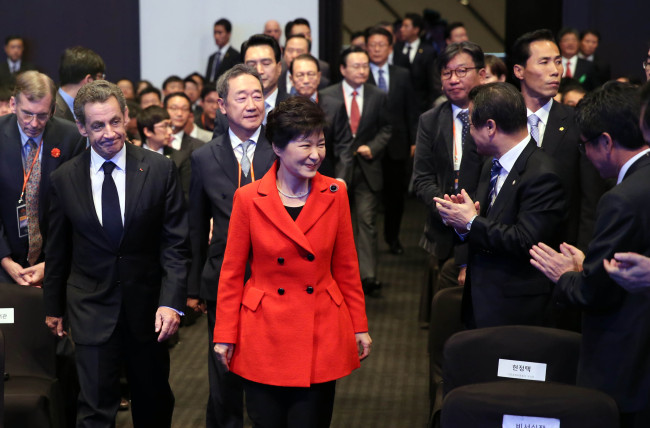 South Korean President Park Geun-hye and former French President Nicholas Sarkozy enter the conference hall to attend the opening ceremony of the World Knowledge Forum at a hotel in central Seoul on Tuesday.   Yonhap