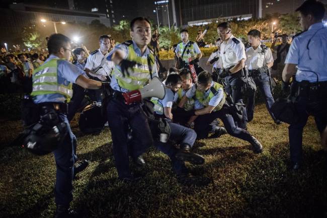 Police forces arrest pro-democracy protesters outside the central government offices in Hong Kong on Tuesday.   AFP-Yonhap
