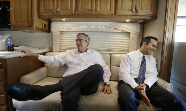 George P. Bush (right) laughs after his father former Florida Gov. Jeb Bush makes a joke during an interview on a campaign bus in Abilene, Texas, Tuesday.    AP-Yonhap
