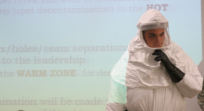 Cpl. Zachary Wicker shows how to put on a germ-protective suit in Fort Bliss, Texas, Tuesday. About 500 Fort Bliss soldiers are preparing for deployment to West Africa where they will provide support in a military effort to contain the Ebola outbreak.   AP-Yonhap