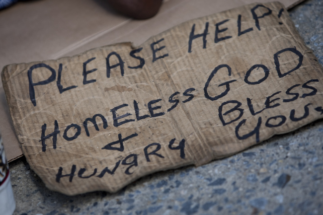 A sign next to a homeless man in New York.   Bloomberg
