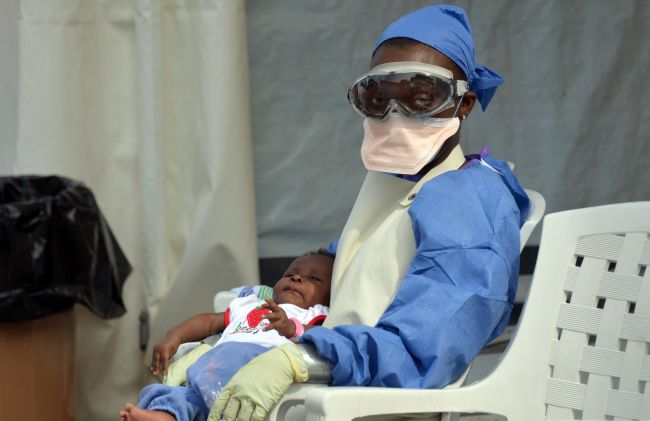A Liberian health workers holds a baby infected with the Ebola virus at the NGO Medecins Sans Frontieres Ebola treatment center in Monrovia on Saturday.    AFP-Yonhap