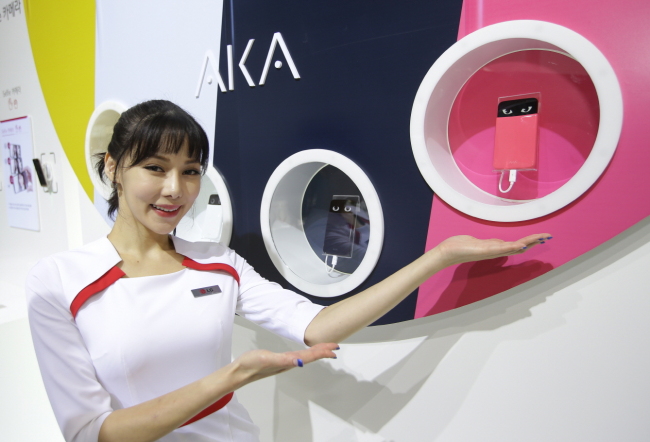 A model poses with LG Electronics’ new concept smartphone, AKA at the World IT Show in Busan on Monday. The phone, which can be customized to the individual consumer’s taste in animation functions, will hit the local market next month.   LG Electronics