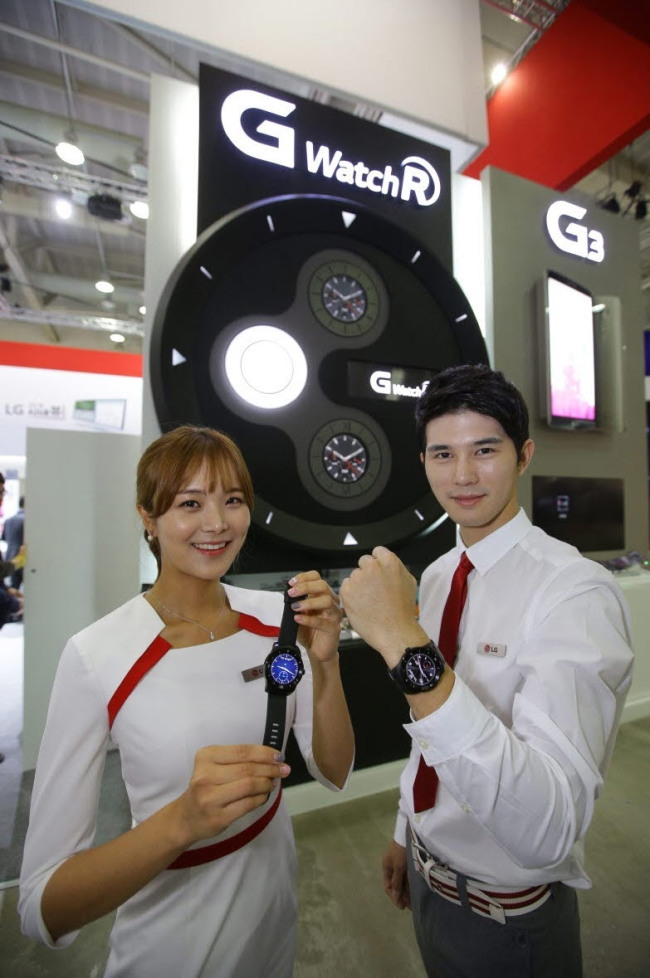 Models pose with LG Electronics’ LG G Watch R smart watch aligned with the company’s new vision for 5G communications in Busan on Monday.   LG Electronics