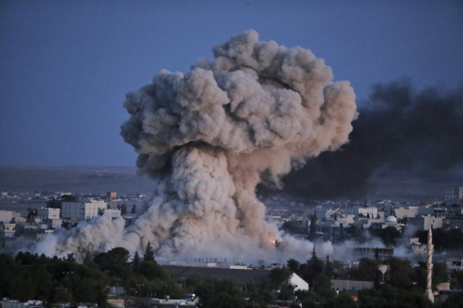 <YONHAP PHOTO-0039> Thick smoke from an airstrike by the US-led coalition rises in Kobani, Syria, as seen from a hilltop on the outskirts of Suruc, at the Turkey-Syria border, Monday, Oct. 20, 2014 Kobani, also known as Ayn Arab, and its surrounding areas, has been under assault by extremists of the Islamic State group since mid-September and is being defended by Kurdish fighters. (AP Photo/Lefteris Pitarakis)/2014-10-21 05:28:48/ <저작권자 ⓒ 1980-2014 ㈜연합뉴스. 무단 전재 재배포 금지.>
Smoke from an air strike by the U.S.-led coalition rises in Kobane, Syria, as seen from a hilltop on the outskirts of Suruc at the Turkey-Syria border Monday.   AP-Yonhap