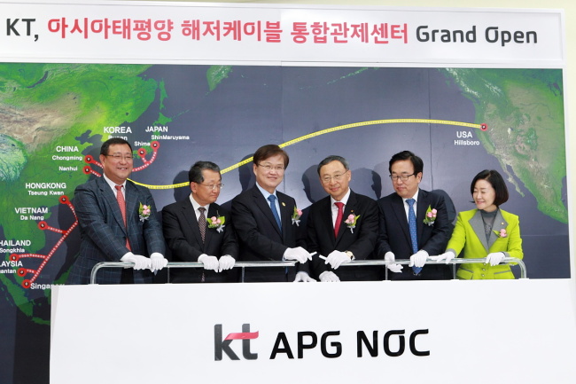 KT CEO Hwang Chang-gyu (third from right) and ICT Minister Choi Yang-hee (third from left) connect a cable with other officials, including China Unicom general manager Yan Bo (left), to launch a network center in Haeundae, Busan, Tuesday. The center will manage and maintain the world’s biggest set of underwater cables, linking Korea with eight Asian countries.   KT