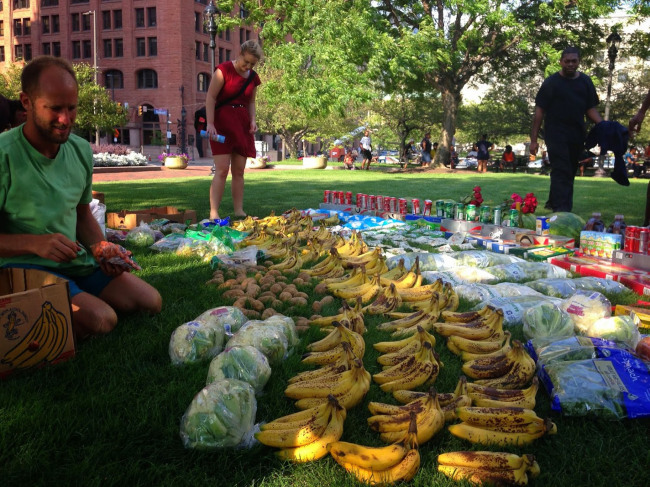 All of the food laid out on the grass in Cleveland’s Public Square was saved from dumpsters by Rob Greenfield (left), an environmental activist bicycling across the U.S., eating only food he finds in dumpsters. (Los Angeles Times/MCT)